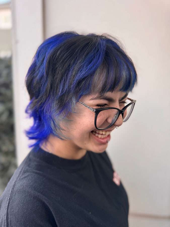 Woman with blue hair smiling at Salon 730 in Fredericksburg VA