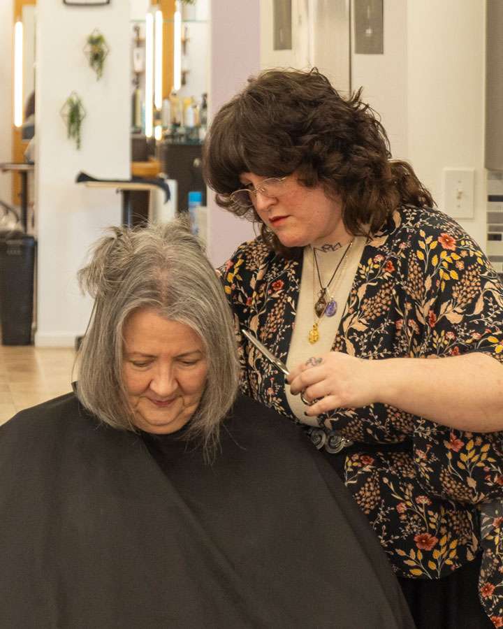 Hair stylist cutting a client's hair at Salon 730
