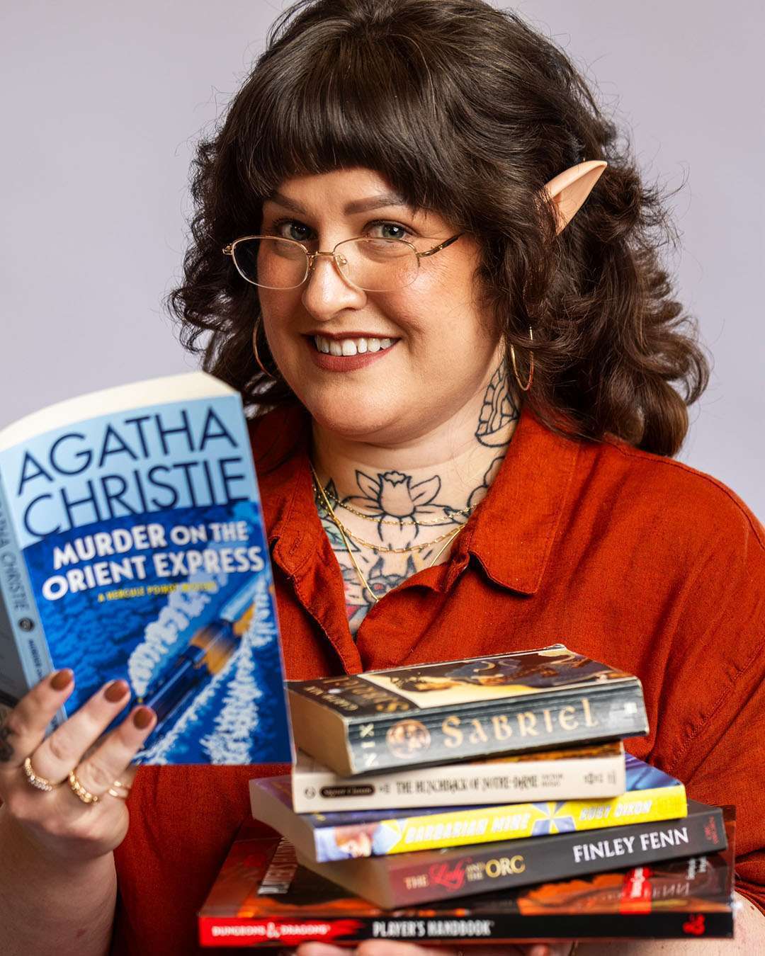 Ella, hairstylist at Salon 730 in Fredericksburg VA holding a stack of books