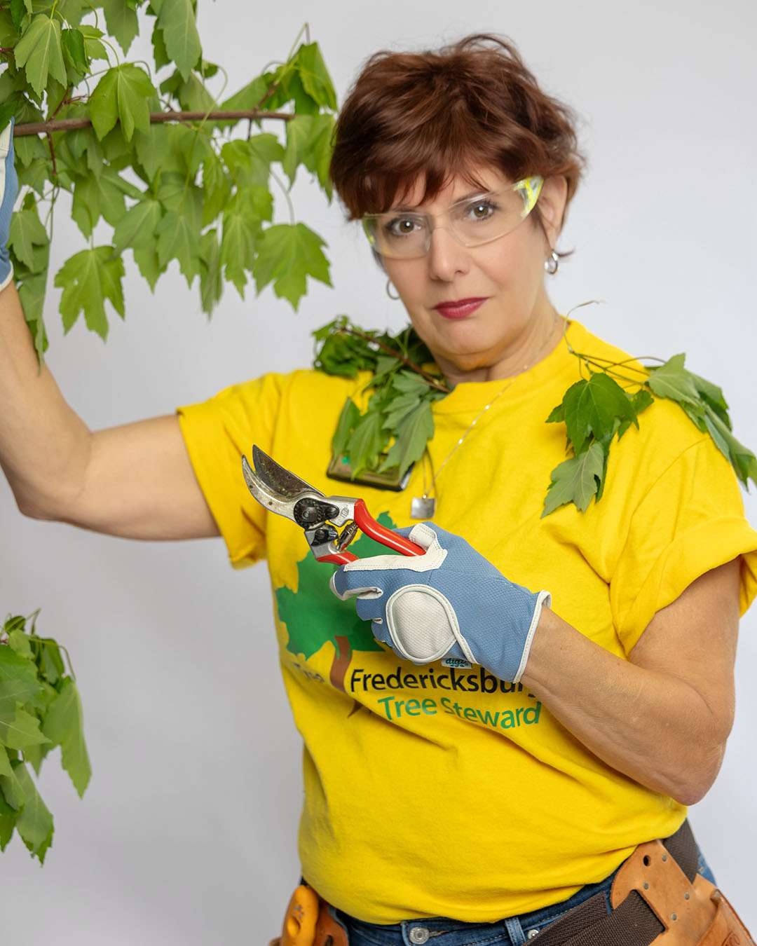 Rita, hairstylist at Salon 730 in Fredericksburg VA pruning branches from a tree